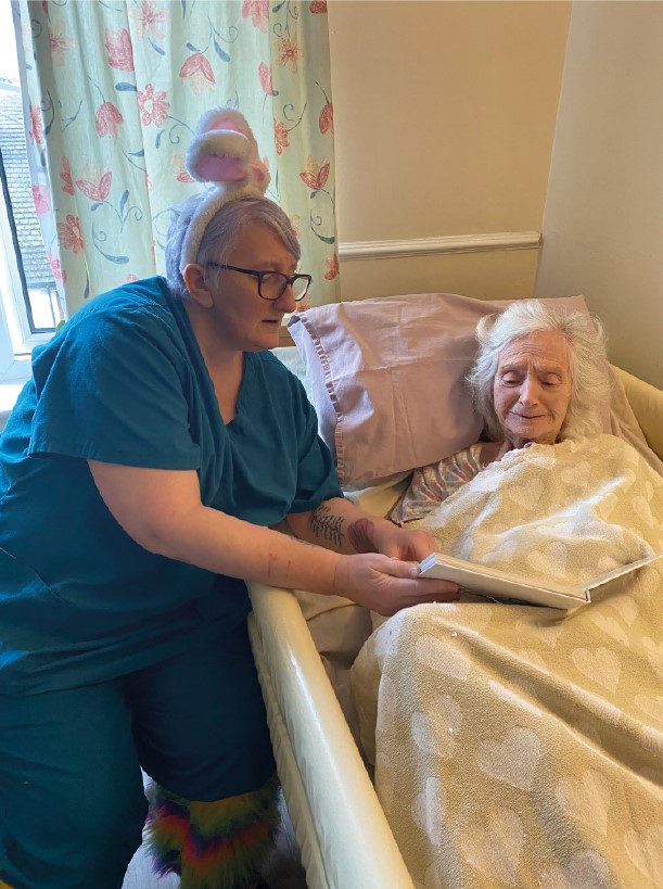 Debbie, a carer at Kingston Court in Carlisle, shares a photo album with one of our residents. 