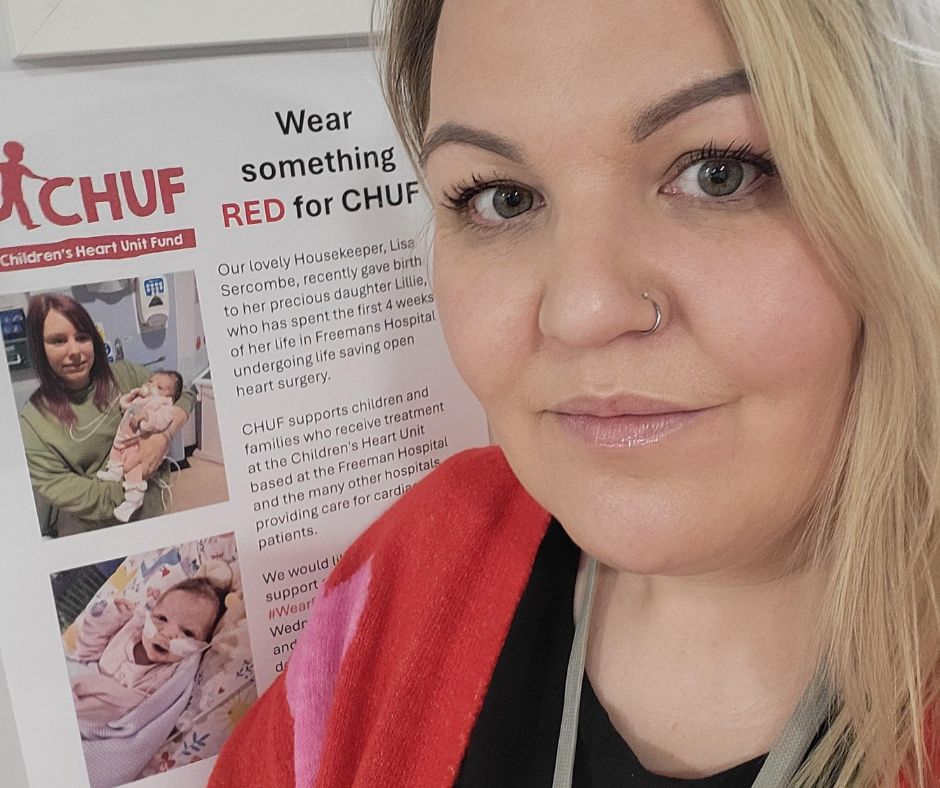 Emma, a Business Administrator in a care home in Carlisle, stands in front of a poster for the charity CHUF. 